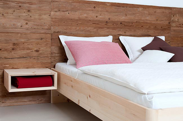Modernes Schlafzimmer mit Massivholzbett, Holzvertäfelung und schwebendem Nachttisch.