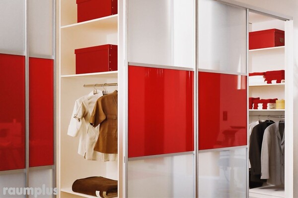 Moderner Kleiderschrank mit roten Schiebetüren, Regalen und hängender Kleidung.