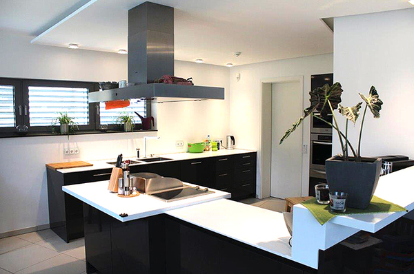 Moderne offene Küche mit Kochinsel, weißen Arbeitsplatten und großen Fenstern.