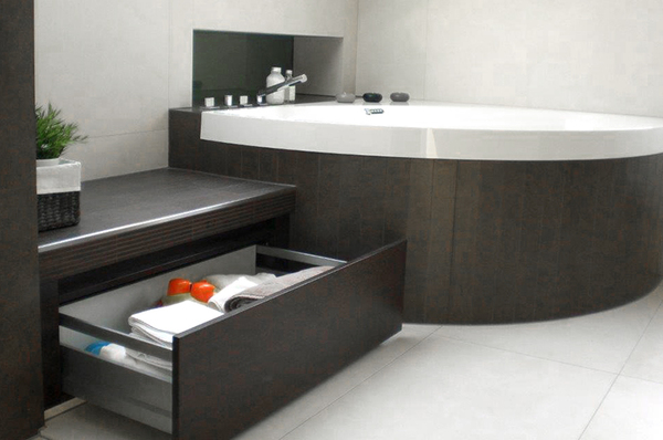 Modernes Badezimmer mit großer Badewanne, dunklem Holz und praktischem Stauraum.